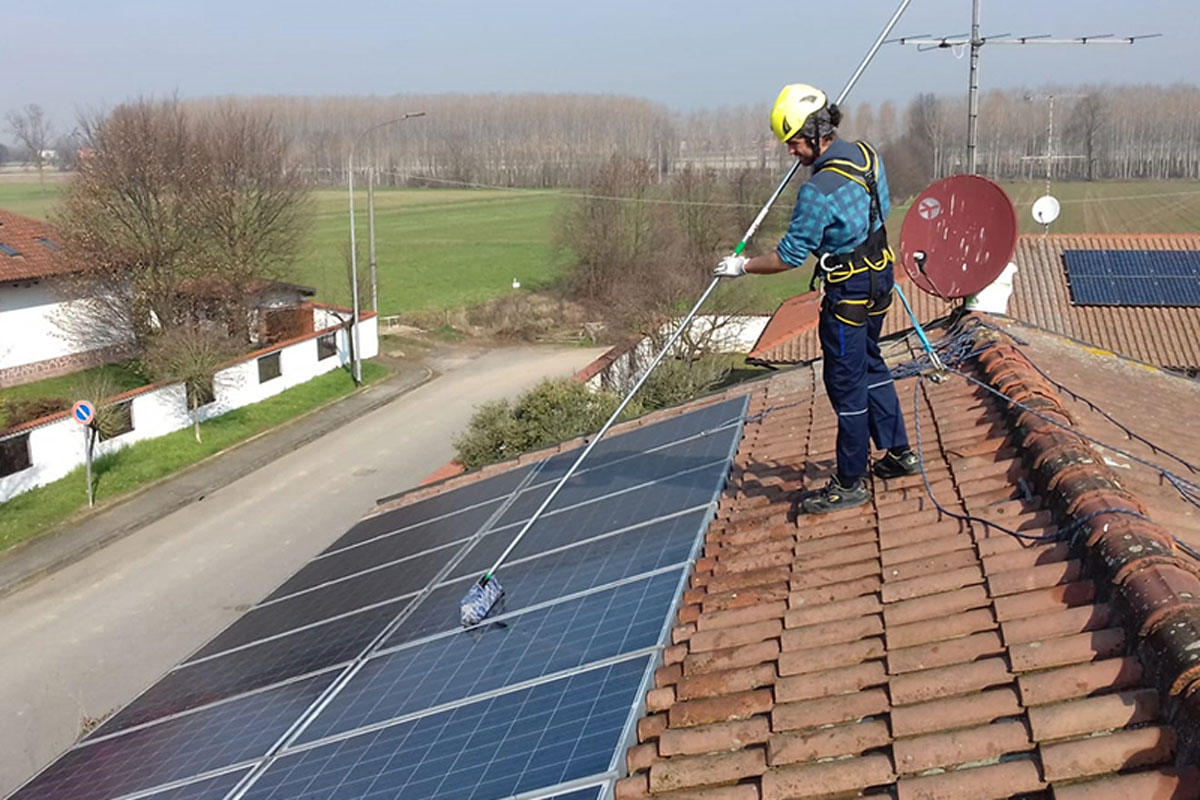 Worker cleaning solar panels after installation outdoors